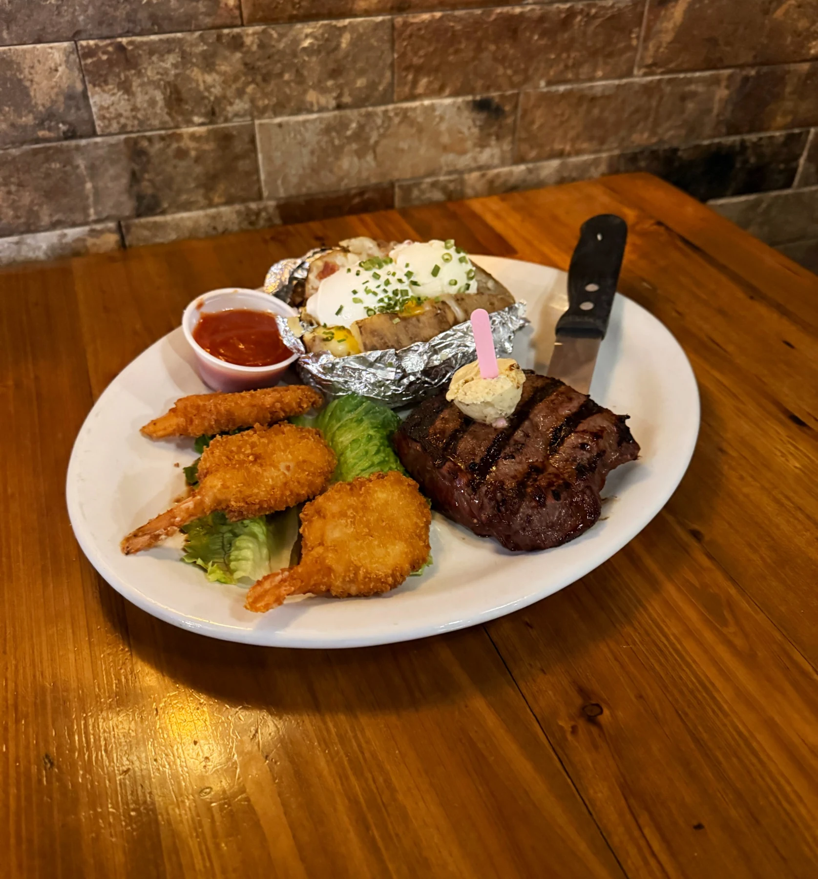 Boomers’ grilled steak with butter, breaded shrimp and a loaded baked potato